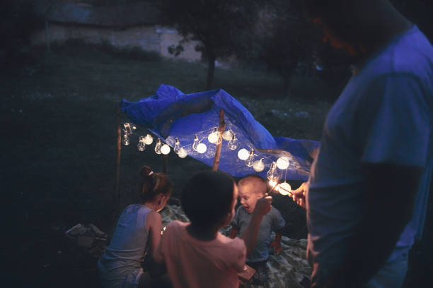 istock Father with children playing under their backyard tent. 1169503303