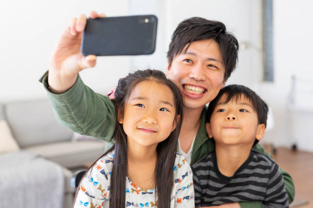 istock Father Sitting Hugging His Two Children 1169504017