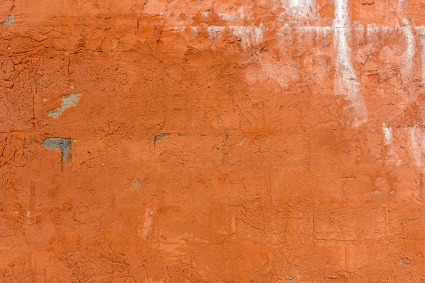 istock Textured surface of an old orange painted concrete wall 1169504470