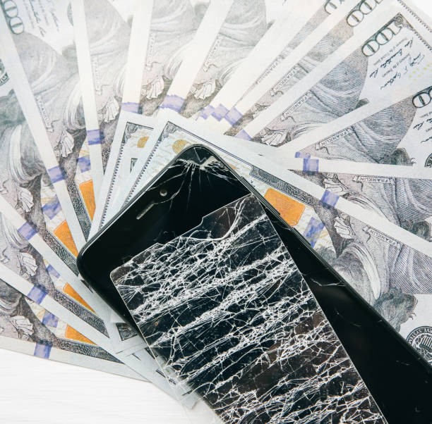 istock Broken screen protector tempered glass. Money lying near the phone. Dollar notes. 1169514425