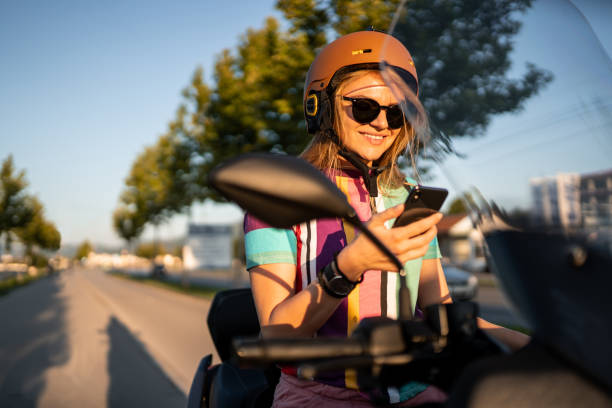 istock Beautiful young girl on scooter using phone 1169514938