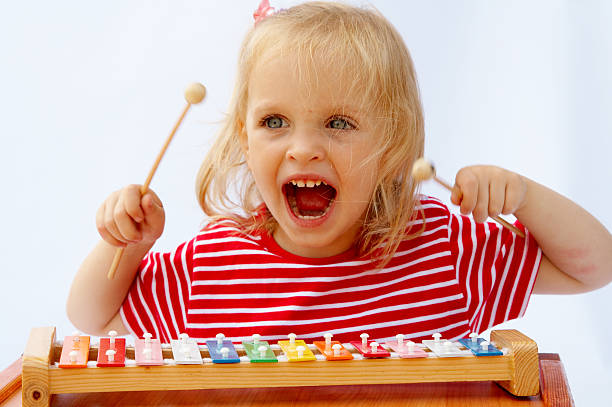 Rainbow xylophone Little girl wearing striped red t-shirt playing the rainbow xylophone toddler hitting stock pictures, royalty-free photos & images