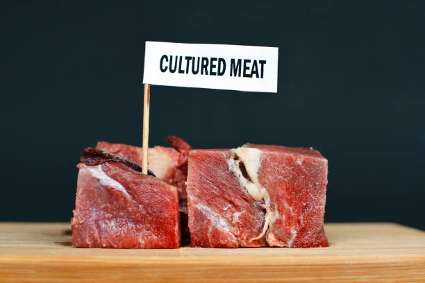 duże kawałki surowego czerwonego mięsa na drewnianej płycie z napisem "mięso hodowane", koncepcja sztucznej produkcji mięsa - heathy food zdjęcia i obrazy z banku zdjęć