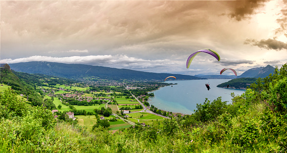 Paragliders with parapente jumping  near of the lake of Annecy in French Alps, in France