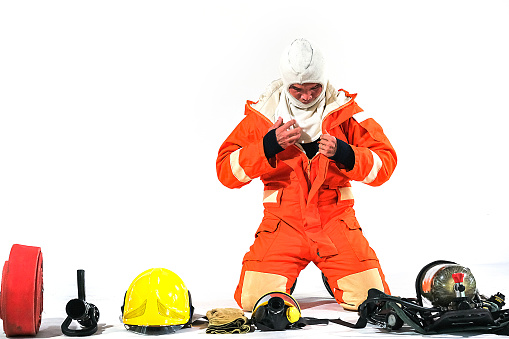 Firefighter demonstrates wearing uniforms, helmets and various equipment to prepare firefighters on a white background.