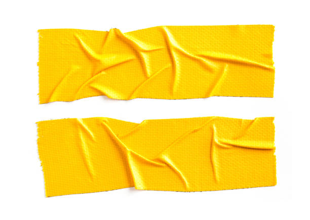 Crumpled pieces of yellow cloth gaffer tape isolated on white background. stock photo