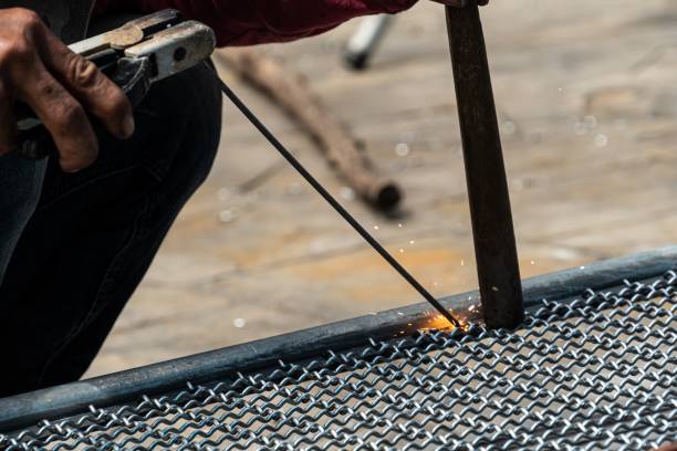 istock worker used electric welding wire mesh to make bird cage. 1169521314