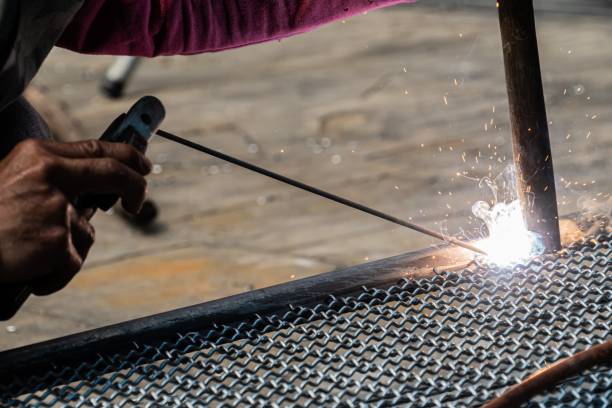 istock worker used electric welding wire mesh to make bird cage. 1169521370