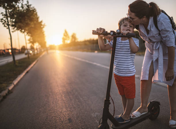 istock Little boy riding a electic push scooter with his mom 1169522196