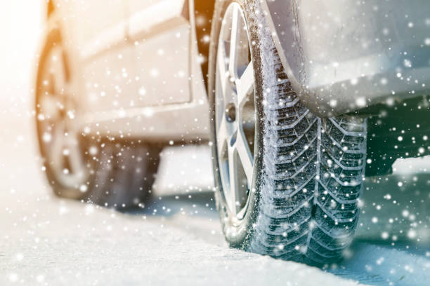 primer plano de las ruedas de coche neumáticos de goma en la nieve de invierno profunda. concepto de transporte y seguridad. - snow car winter road fotografías e imágenes de stock