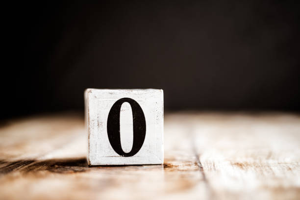 istock 0 - Number 0 - Number Zero - White block with number on wooden table and dark background 1169524799