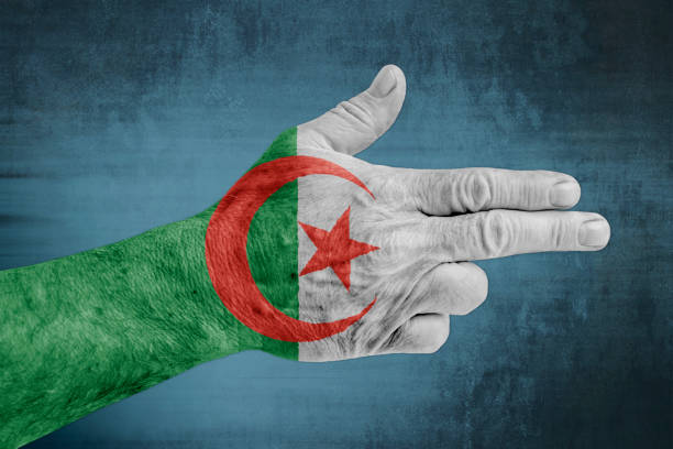 istock Algeria flag painted on male hand like a gun 1169524921