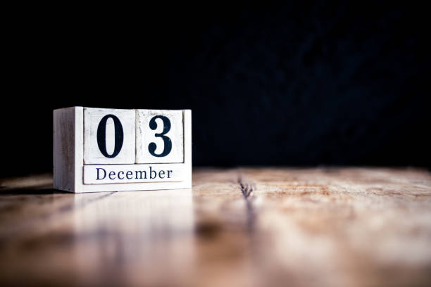 istock December 3rd, 3 December, Third of December - White block calendar on vintage table - Date on dark background 1169524982