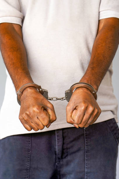 istock Arrested african man with handcuffs 1169526515