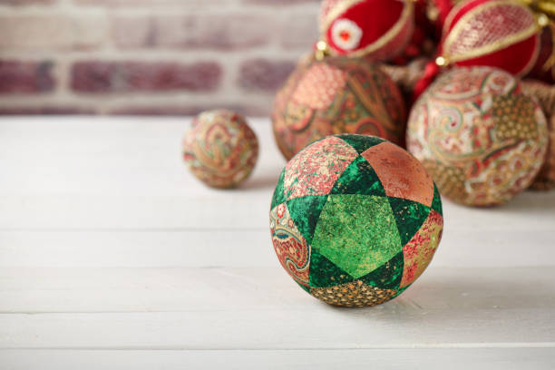 patchwork puzzle balls and christmas decorations in basket on brick wall background - christmas quilt craft patchwork imagens e fotografias de stock