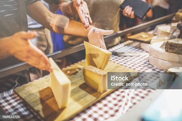 Man Preparing Cheese Slices On Wooden Board At Street Market Stock Photo - Download Image Now