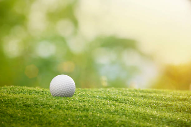 ゴルフボールは美しいゴルフコースの緑の芝生の上にあります - golf golf flag sunset flag ストックフォトと画像