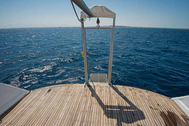 Deck of a luxury modern yacht with closed hatches and steps.