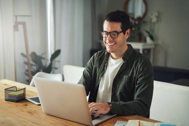 istock Happy man wearing eyeglasses using laptop at home 1169538088