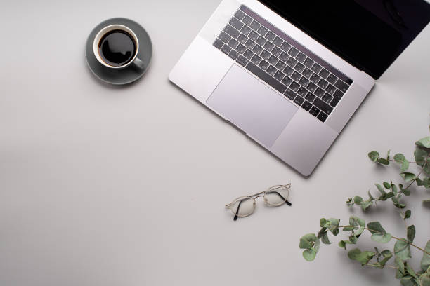 istock Flatlay with laptop, eucalyptus and a cup of coffee on gray background. Workspace concept. Copy space 1169539331
