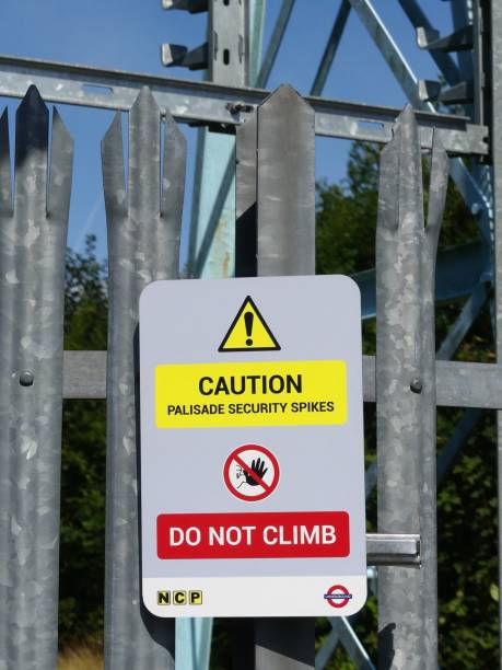 aparcamientos nacionales y cartel del metro de londres que lee precaución palisade picos de seguridad no subir - railroad spikes fotografías e imágenes de stock