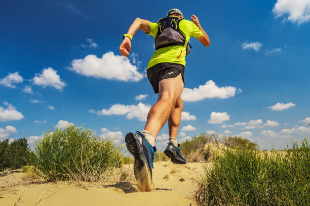 istock Athlete runs along the sandy desert. Desert trail running 1169539573