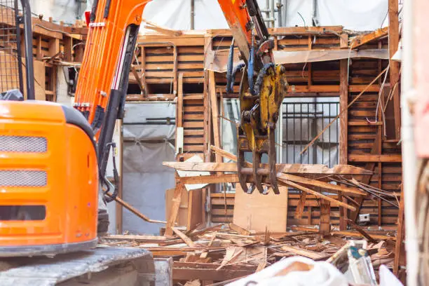 Backhoe is demolish old house for do building new house.