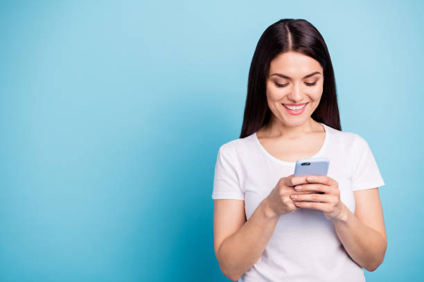 istock Copyspace photo of cheerful nice cute girlfriend browsing through her telephone while isolated with blue background 1169541501