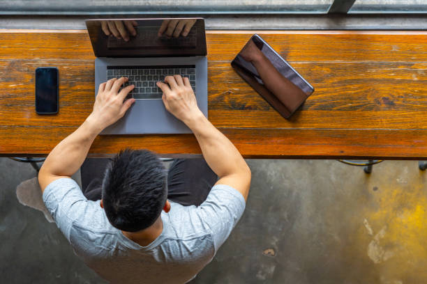 istock Asian freelancer typing laptop next to tablet and smart phone 1169543229
