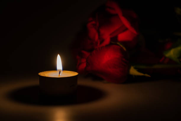 istock tealight candle and red rose at midnight time 1169543340