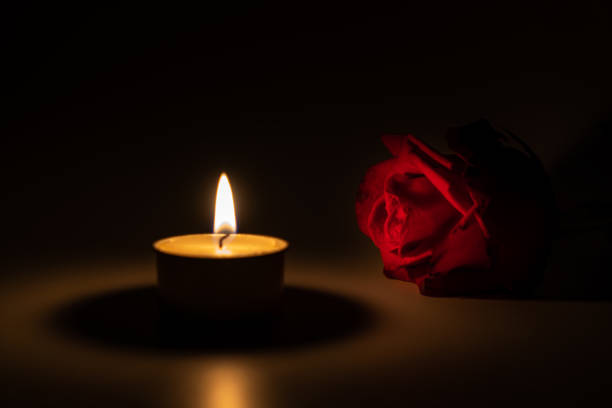 istock tealight candle and red rose at midnight time 1169543345