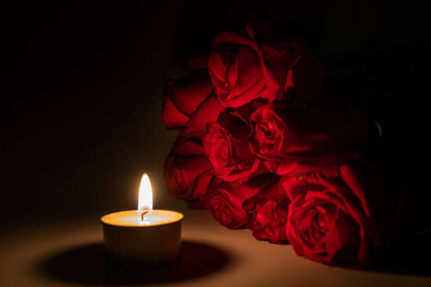 istock tealight candle and red rose at midnight time 1169543352