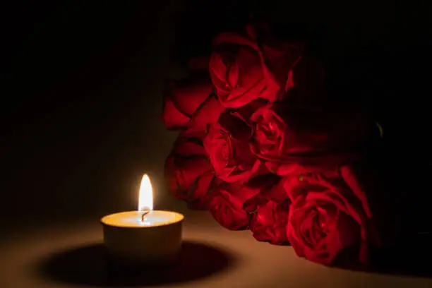tealight candle and red rose at midnight time