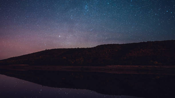 istock Starry sky over mountain and river at night.Constellations and planets beautifully reflected in water.Milky way.Nature, universe, galaxy, astronomy concept. 1169543460