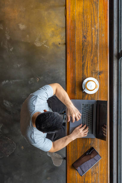 istock Vertical photo of Asian freelancer using laptop at rustic coffeeshop 1169544302