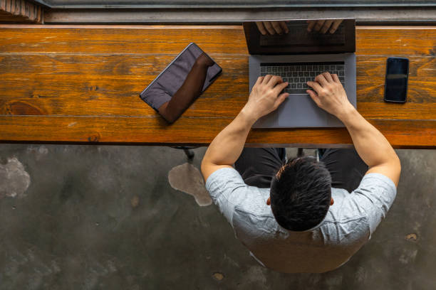 istock Top view of young freelancer typing laptop next to tablet 1169544712