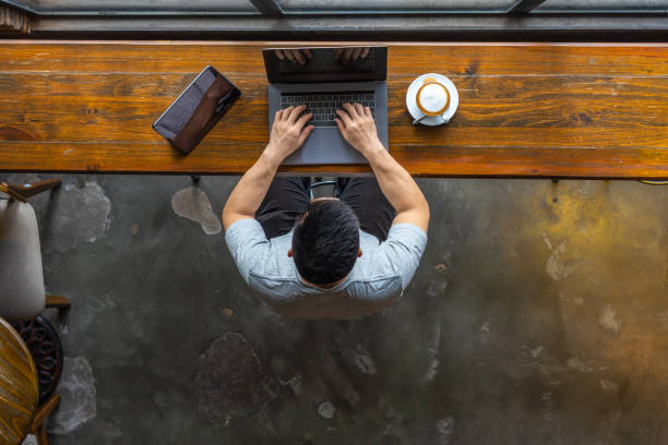 istock Isolated young Asian freelancer using laptop at rustic coffeeshop 1169546297