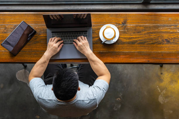 istock Young Asian freelancer using laptop and tablet at beautiful coffeeshop 1169546520