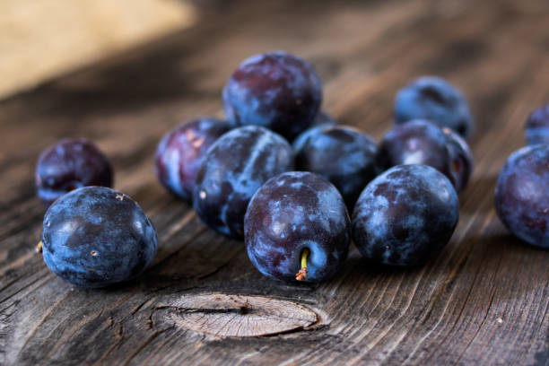 istock Fresh organic plums on old wooden table. 1169546527
