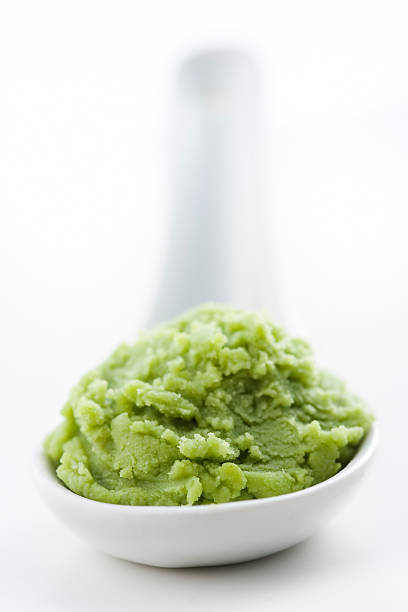 Wasabi Authentic wasabi in a white spoon (it could be used too as mint or pistaccio ice cream for the colors and texture). wasabi sauce stock pictures, royalty-free photos & images