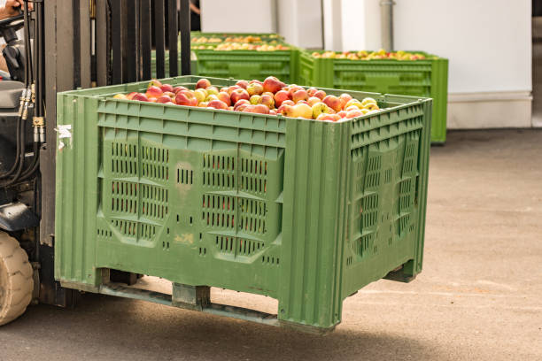 o forklift carreg caixas da fruta. muitas maçãs no recipiente - warehouse box crate storage room - fotografias e filmes do acervo