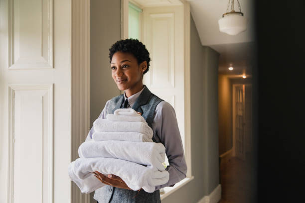 Clean and Fresh Cotton Towels A side view of a woman working in a hotel, holding fresh towels for a hotel room. room service stock pictures, royalty-free photos & images