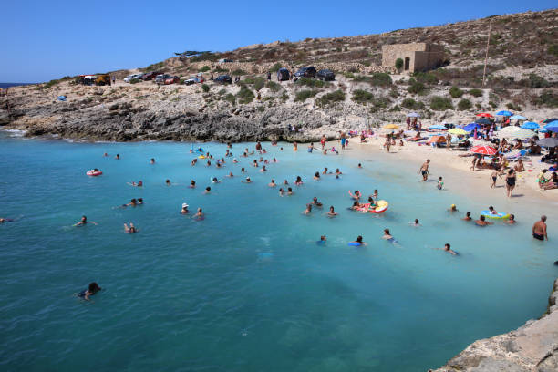 Many unidentified People on the Beach of Hondoq Bay. Island of Gozo. Malta stock photo