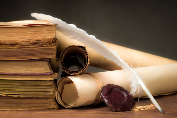 istock Papyrus scrolls on a table top with books and pen 1169549075