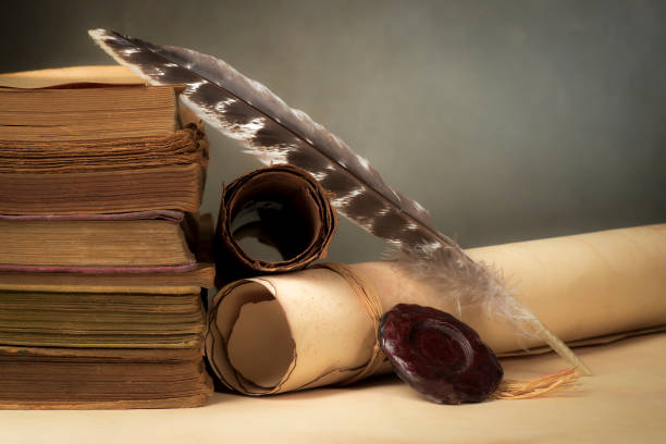 istock Papyrus scrolls on a table top with books and pen 1169549206