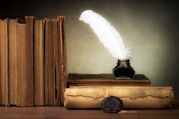 istock Papyrus scrolls on a table top with books, pen and inkwell 1169549229