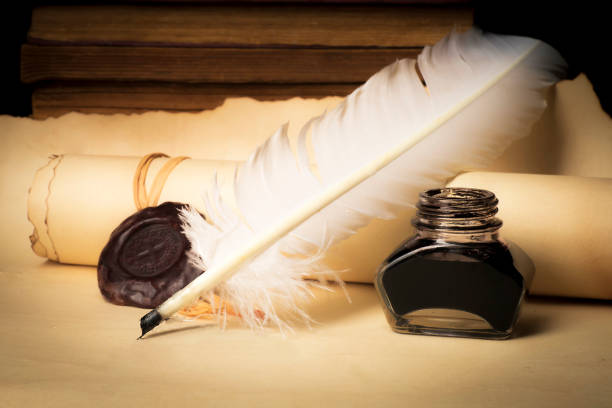 istock Papyrus scrolls on a table top with books, pen and inkwell 1169549561