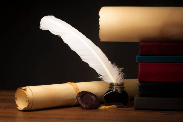 istock Papyrus scrolls on a table top with books, pen and inkwell 1169549620
