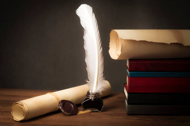 istock Papyrus scrolls on a table top with books, pen and inkwell 1169549675