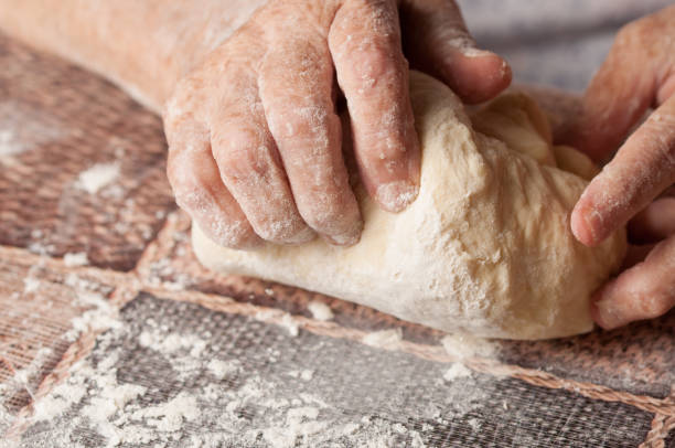 mulher que faz o dought. dought para a pizza e o pão. alimentos. - bread kneading making human hand - fotografias e filmes do acervo